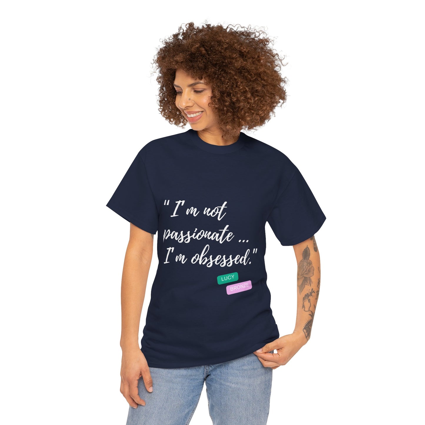 Unisex heavy cotton T-shirt with bold “Not Passion. Obsession.” text design, inspired by the ethos of being Unapologetically Obsessed. Available in charcoal, black, light pink, navy, and sport grey. Emphasizes quality, comfort, and the story of autism and ADHD empowerment tied to the Lioness icon.