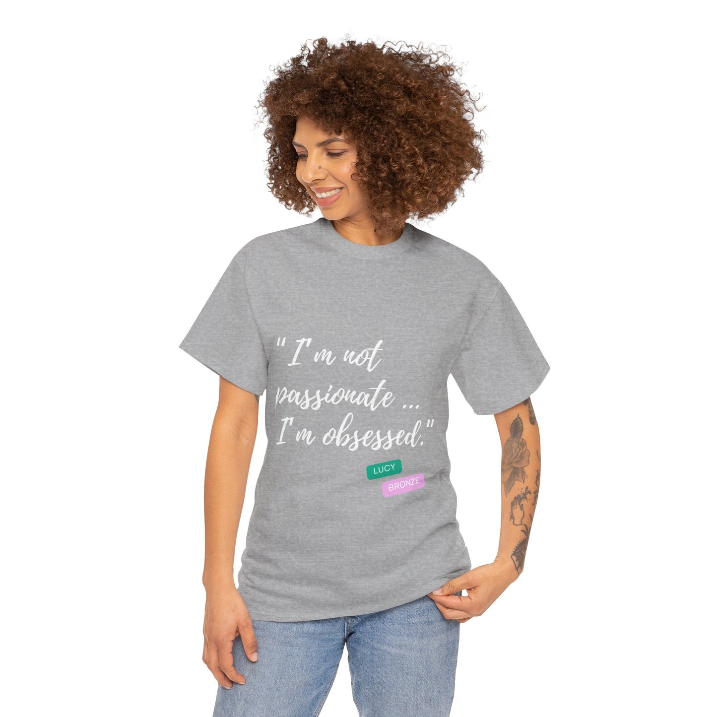 Unisex heavy cotton T-shirt with bold “Not Passion. Obsession.” text design, inspired by the ethos of being Unapologetically Obsessed. Available in charcoal, black, light pink, navy, and sport grey. Emphasizes quality, comfort, and the story of autism and ADHD empowerment tied to the Lioness icon.