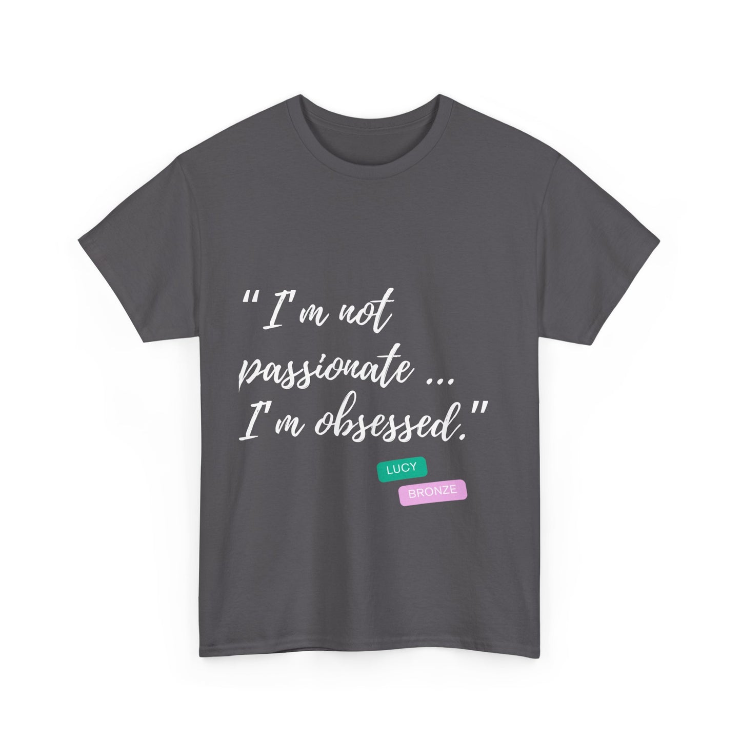 Unisex heavy cotton T-shirt with bold “Not Passion. Obsession.” text design, inspired by the ethos of being Unapologetically Obsessed. Available in charcoal, black, light pink, navy, and sport grey. Emphasizes quality, comfort, and the story of autism and ADHD empowerment tied to the Lioness icon.