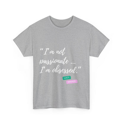 Unisex heavy cotton T-shirt with bold “Not Passion. Obsession.” text design, inspired by the ethos of being Unapologetically Obsessed. Available in charcoal, black, light pink, navy, and sport grey. Emphasizes quality, comfort, and the story of autism and ADHD empowerment tied to the Lioness icon.